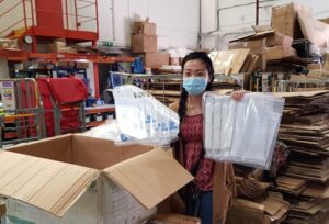 Volunteer Jiang is looking for PPE at the warehouse.